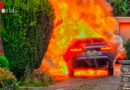 D: Hybrid-SUV neben einem Wohnhaus in Vollbrand